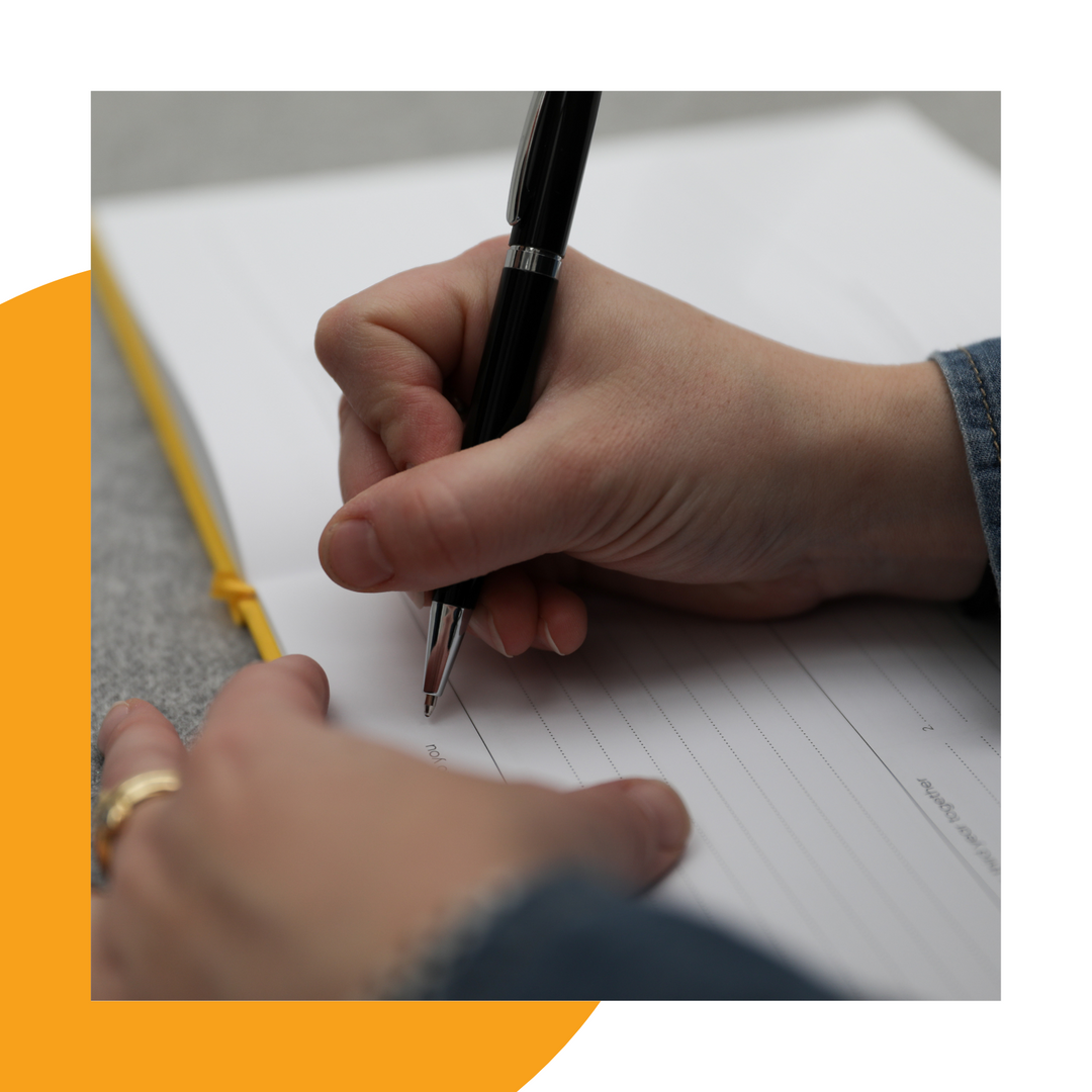 Parent writing in childhood memory journal The Book of You. 
