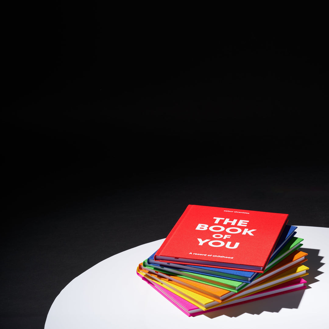 Childhood memory journals in a stack shown in theatrical limelight
